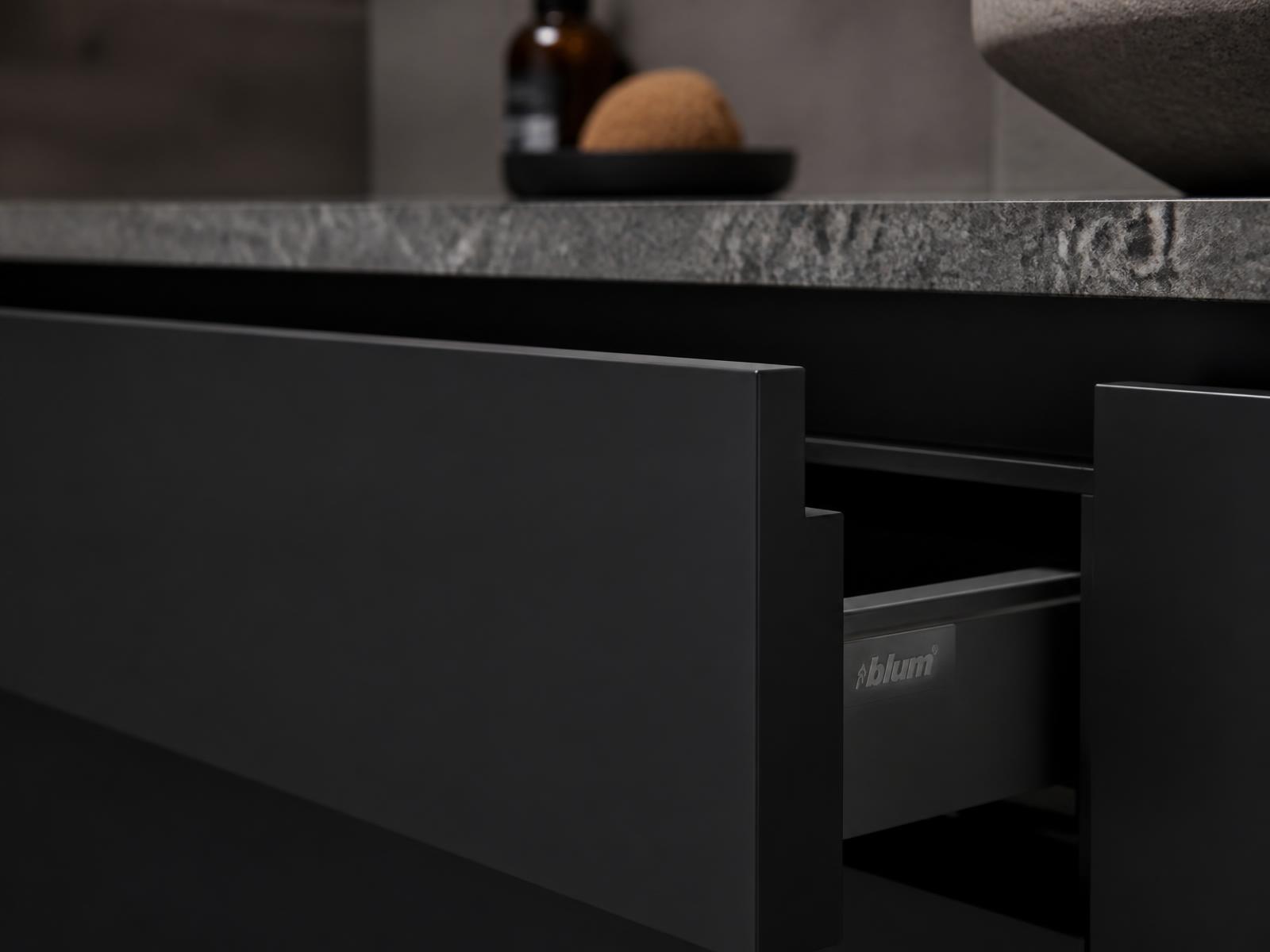 Detalj av lådfront i svart matt med granitskiva på Cabinex badrumsmöbel